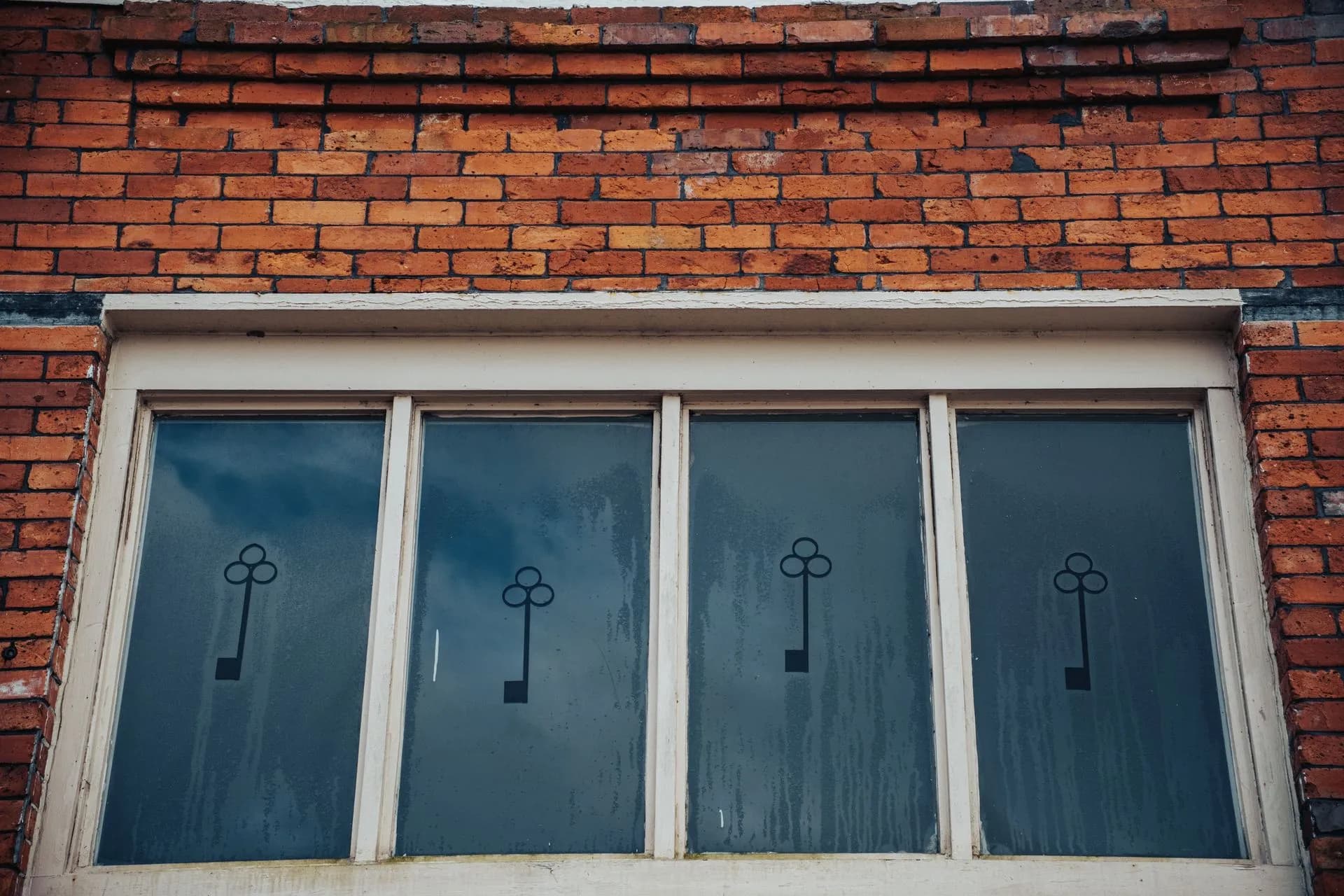 Close-up of a vintage brick wall with decorative frosted glass windows and key motif, illustrating AppFolio Realm-X takes on multi-step work as AI startup EliseAI hits $4 billion