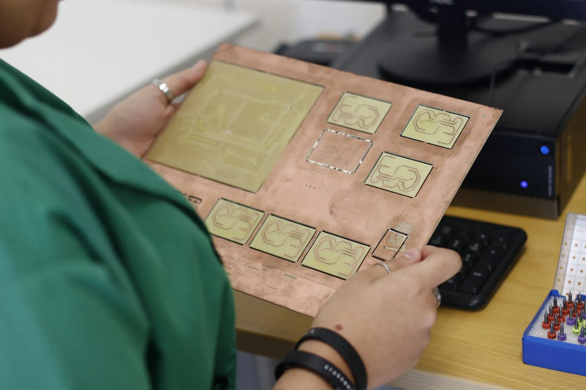 A technician examines a printed circuit board in a modern electronics lab, illustrating OneTrust CORIE polices AI agents in real time as its survey finds 86% had AI incidents